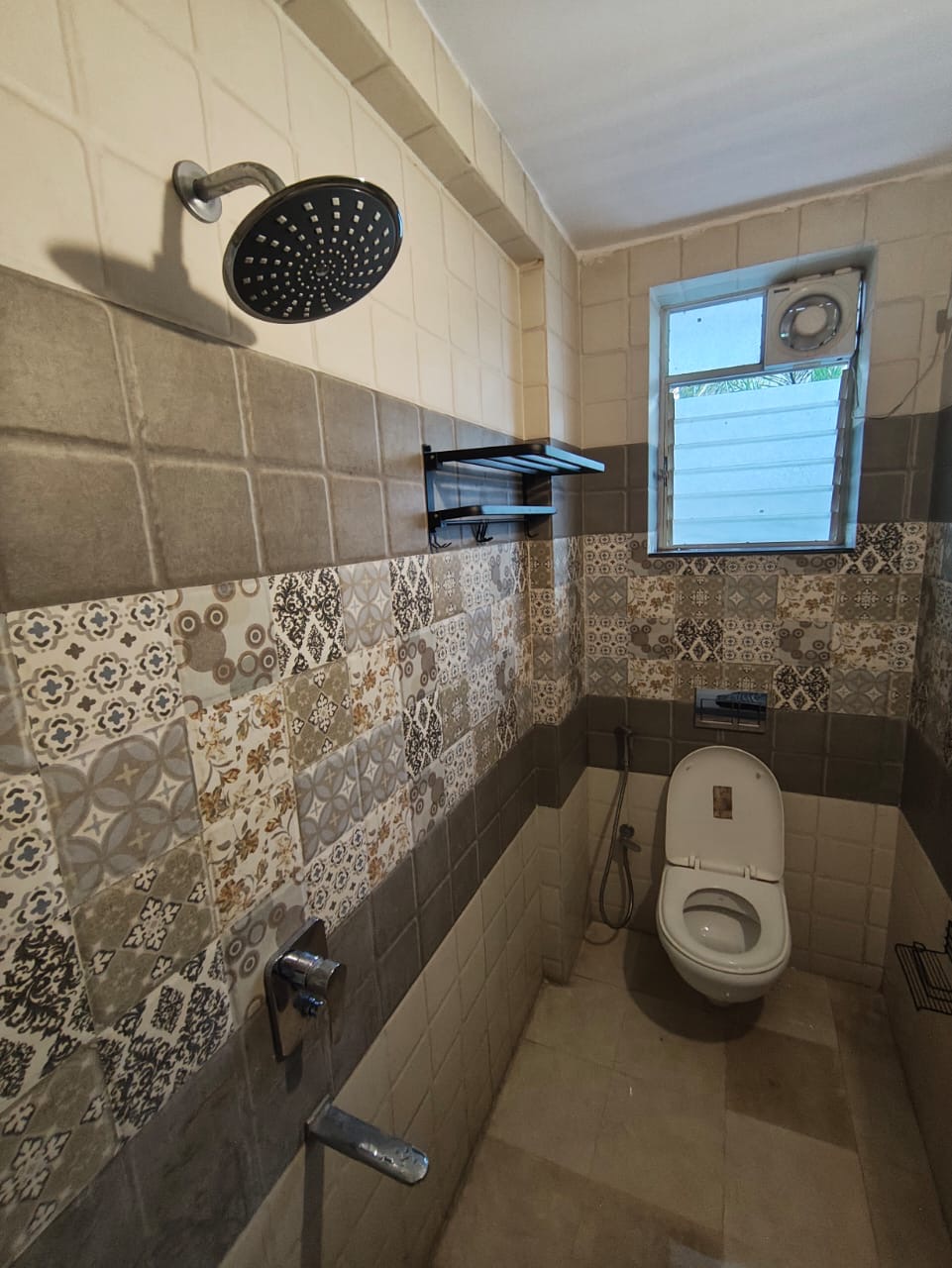 Bathroom with rain shower and patterned mosaic tile feature wall